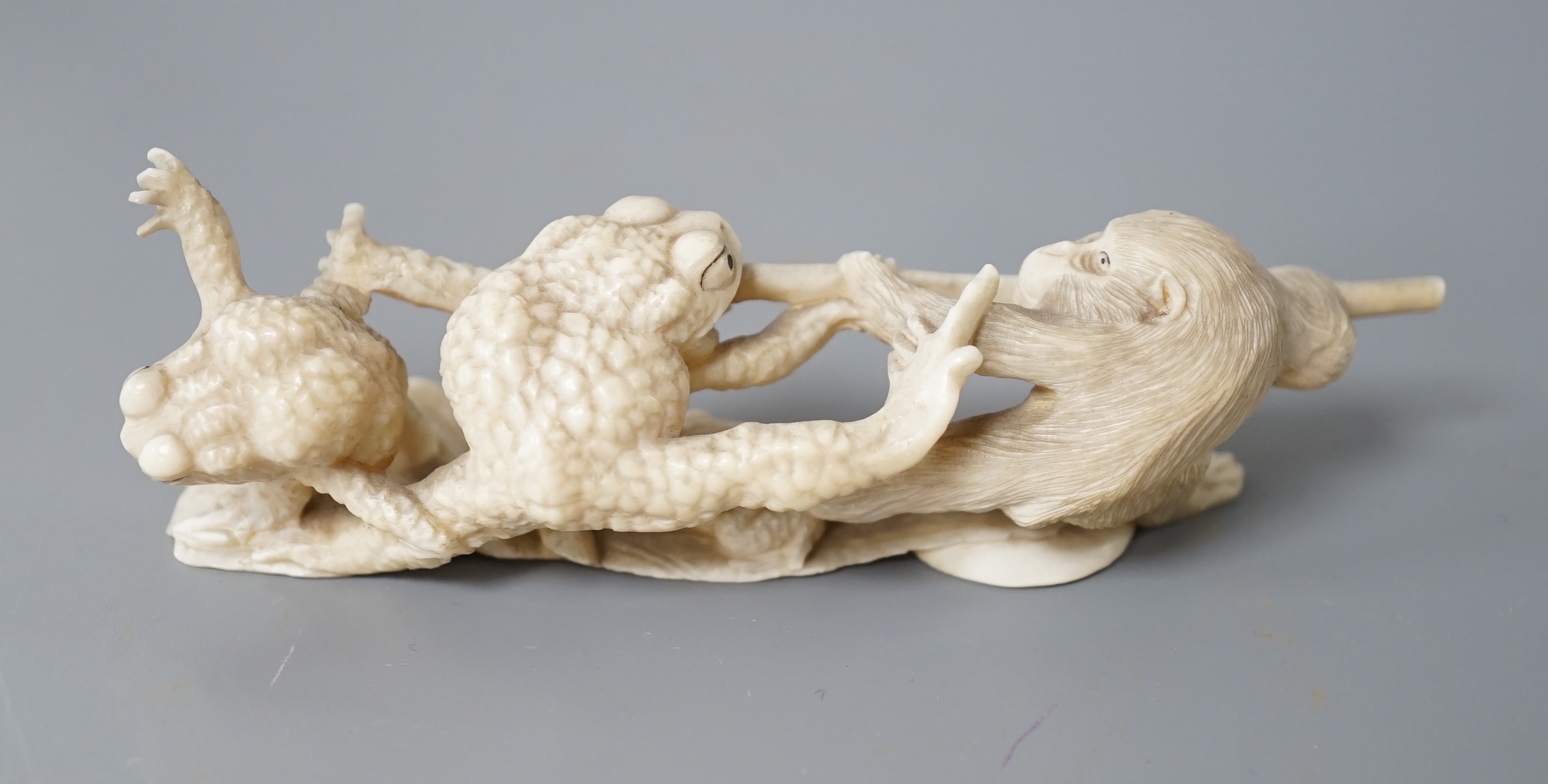 A Japanese ivory okimono of a monkey and toads, Meiji period, 12cm